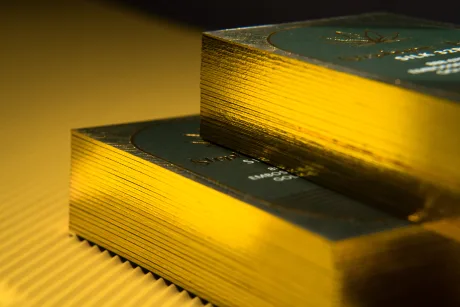 Macro shot of a stack of business cards showing a thick, gleaming gold foiled edge