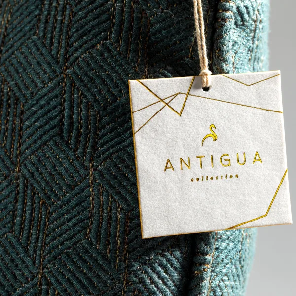 A cream textured hang tag with a gold foil geometric line design, strung with gold cord.