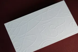 An embossed design pressed into the card, creating tactile depth.