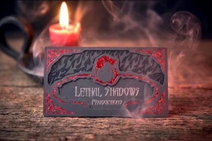 A SilkCards business card with raised foil lettering catching the light.