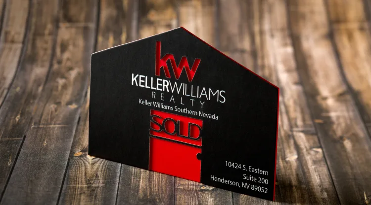 Black suede Keller Williams Realty card with a house-shaped die cut revealing red, and red foiled edges